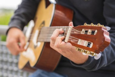 Genç adam sahada gitar çalıyor. 