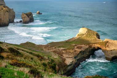 Tunnel Sahili Dunedin NZ 'deki uçurumun tepesinde okyanus boşluktan girip çıkıyor.