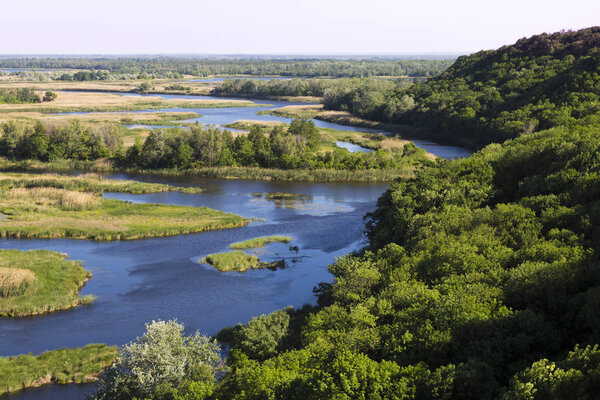 Vorskla river delta at summer day. Nature reserve landscape of Ukraine. Beautiful view from above on a meandering flat river- flood plain. Aerial photography