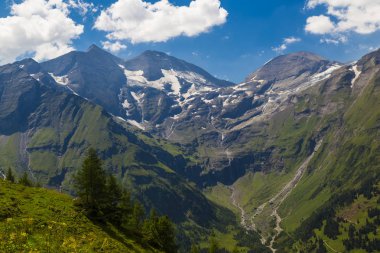 Alp dağ manzarası, yaz. Yeşil vadi, dağ zirveleri mavi bulutlu gökyüzü karşı kar ile kaplı. Grossglockner yüksek alp yolu görünümden. Avusturya. Europe
