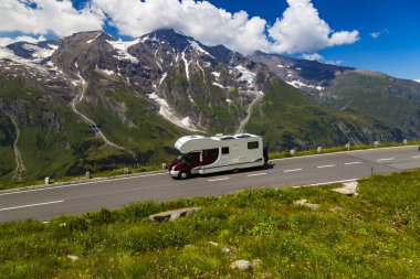Alp dağ manzarası, yaz. Yeşil vadi, dağ zirveleri mavi bulutlu gökyüzü karşı kar ile kaplı. Yolda römork. Grossglockner yüksek alp yolu. Avusturya. Avrupa. Turizm, turistik, karavan