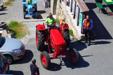 08/04/2018. Grossglockner yüksek alp yolu. Avusturya. Tyrol. Bir dağ yolda motor ralli traktör kulübü. İnsanlar eski renk traktör üzerinde dağ serpantin seyahat. Hobi, seyahat, eğlence, aktif yaşam tarzı kavramı.