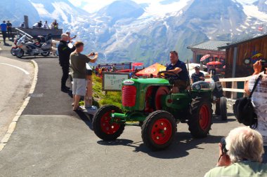 08/04/2018. Grossglockner yüksek alp yolu. Avusturya. Tyrol. Bir dağ yolda motor ralli traktör kulübü. İnsanlar eski renk traktör üzerinde dağ serpantin seyahat. Hobi, seyahat, eğlence, aktif yaşam tarzı kavramı.