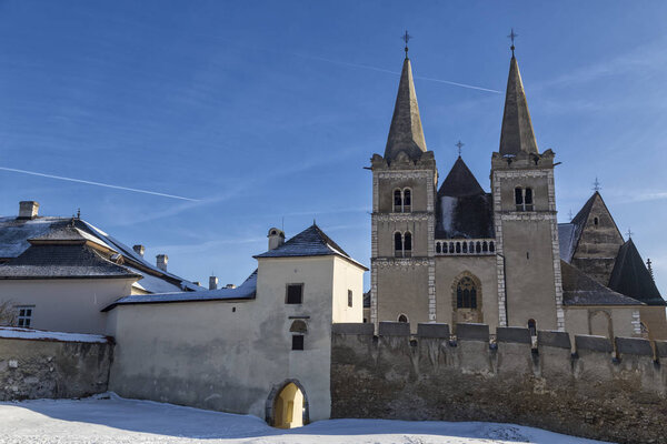 Часовая башня в древней Спиской капитуле на фоне голубого неба зимой. Spisske Podhradie, Slovakia, UNESCO World Heritage Site. Достопримечательности
