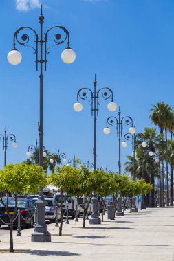 Larnaka seafront, Kıbrıs üzerinde dövme fenerler. Larnaka şehir. Mavi bulutlu gökyüzü arka plan modern Caddesi'nde. Yürüyen turist yer. Ünlü turizm
