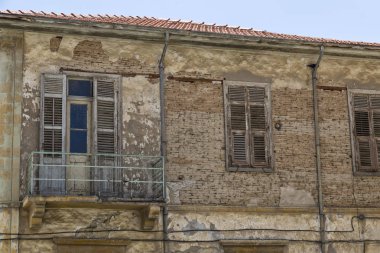 Eski windows ile terk edilmiş bir konut taş ev duvar yıkıldı ve ahşap kepenkleri kapalı. Larnaka şehir. Kıbrıs