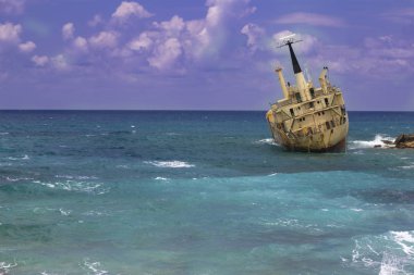 Gemi enkazı. Bulutlu gökyüzü arka plan üzerinde dalgalar ile batık gemi kıyı - turkuaz denize yakın buzlu. Paphos, Kıbrıs yakınındaki Akdeniz kıyılarında. Turizm 