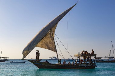 02.12.2019 sahil Zanzibar Adası. Tanzanya. Afrika. Gün batımında okyanus yüzeyindeki Vintage ahşap tekne bir yelken ve turistler gemide. Plaj tatil, eğlence, bilgisiyle