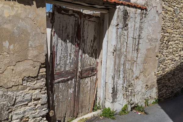 Vecchia porta in legno rotto in casa di pietra abbandonata — Foto Stock