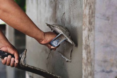 Beton alçıcılar endüstriyel işçilerin arka plan duvarlarını alçılama araçlarıyla donatmak için.