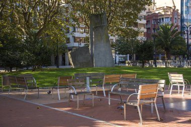 Bir park birkaç banklar, yeşil ciğeri ve güneş ışığı ile fotoğraf
