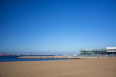 Mavi gökyüzü, plaj ve güneş ışığı ile bir manzara fotoğrafı