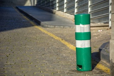 Taş zemin ve güneş ışığı ile yeşil bir sütun fotoğrafı