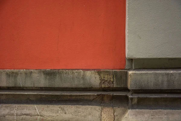 Photo of a facade detail with red colour, cold colours and sunlight.