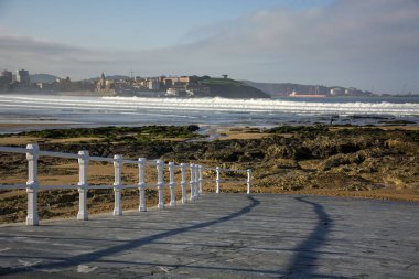 Deniz, kayalar, beyaz korkuluk ve gökyüzü ile Manzara.