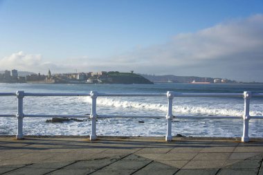 Soğuk renk, deniz, bulutlu gökyüzü ve beyaz korkuluk ile Asturian manzara.