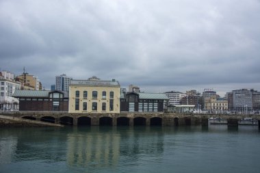 Bulutlu gökyüzü, deniz ve çeşitli binalar ile Asturian deniz.