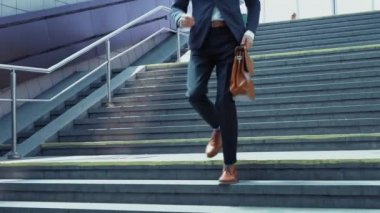 Takım elbiseli genç bir adam elinde bavulla yeraltına iniyor. Ağır çekim. İşler tıkırında. İş konsepti. Prores 422