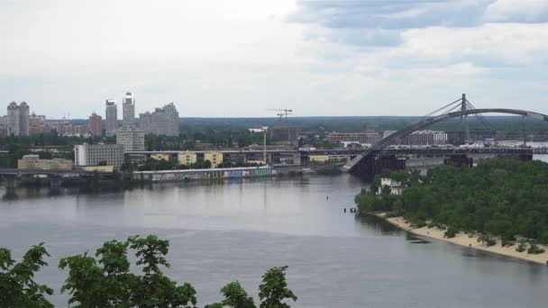 Widok ze szczytu wzgórza do rzeki z niedokończoną budową mostu i miasta miejskiego. maj 2020 r. Kijów, Ukraina. Prores 422 — Wideo stockowe