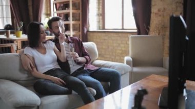 Genç çift bir taşınmayı ya da yıldönümünü televizyon setinin önündeki koltukta oturup düğün günlerini izlerken kutluyor. Prores 422