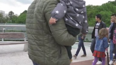Sokak müzisyeninin önünden yürüyen insanlar cam kenarlı köprüde Didgeridoo çalıyorlar. Mayıs 2020. Kiev, Ukrayna. Prores 422. 