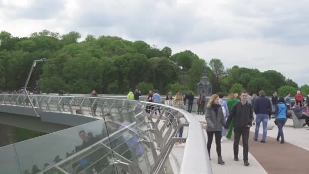 La gente que pasa por el puente a través de la carretera con lados de vidrio a una parte histórica de Kiev. Mayo 2020. Kiev, Ucrania. Prores 422 — Vídeos de Stock
