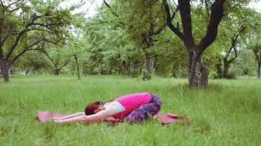 Yoga eğitmeni dışarıda Salabhasana ya da Locust Poz pratiği yapıyor. Yeni başlayanları daha derin sırt bükme hareketleri için hazırlıyor. Spor konsepti. Prores 422