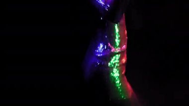 Siyah arka planda neon ışıklarla dans eden seksi Afro-Amerikan modeli. Stüdyoda dans eden güzel bir kız, gümüş renkli bir elbise içinde, siyahların üzerinde izole edilmiş. Neon konsepti. Prores 422