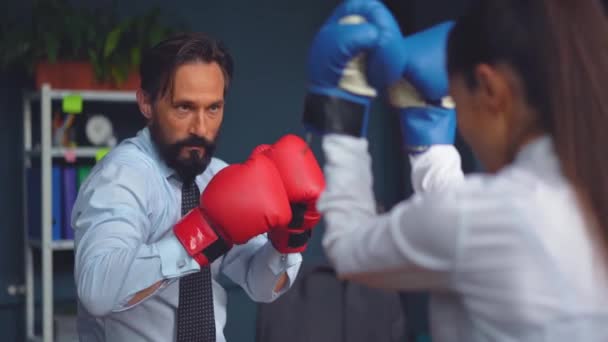 Business people vie boxing on gloves. A man and a woman in business clothes are trying hard to determine which one is stronger. Gender Conflict Concept. Prores 422