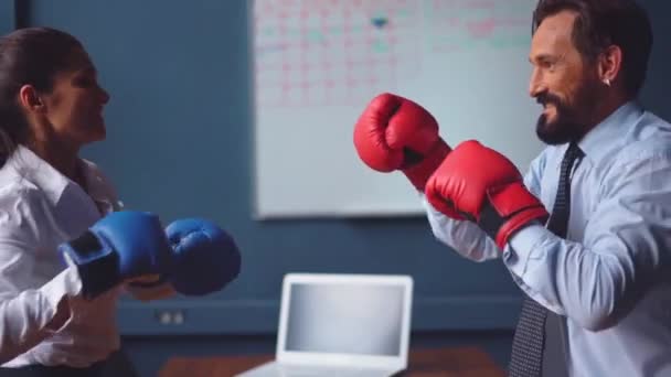 Business people boxing fighting wearing gloves. Man and a woman in business clothes are trying hard to release stressful situations making funny fight. Gender Conflict Concept. Prores 422
