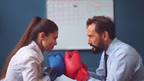 Man frightening woman in business clothes trying hard to determine which one is stronger. Business people vie boxing on gloves. Gender Conflict Concept. Prores 422