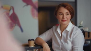 İş kadını iş yerinde ya da kafede kahve içer, yan bakan bir kadın sıcak bir kafede tek kullanımlık bir fincanda taze kahvesinin tadını çıkarır. Prores 422