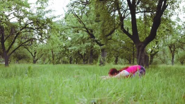 Yoga instructeur fille montrant extension étirement pratiquant à l'extérieur dans le parc ou le jardin. Prores 422 — Video