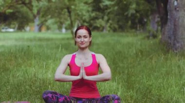 Yoga eğitmeni kız, elleri açık nefes alma tekniği uyguluyor. Parkta ya da bahçede meditasyon yapmak çok zaman alıyor. Prores 422