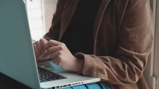 Närbild kvinna arbetar på laptop sitter bredvid fönstret. Frilansare kvinna hittade en gratis lugn plats och arbetar sitter i en turkisk pose. Affärsidé. Prores 422 — Stockvideo