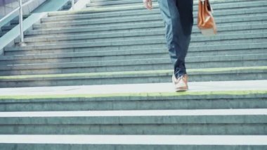 Takım elbiseli genç serbest çalışan elinde evrak çantasıyla yeraltına doğru koşuyor. Ağır çekim. İşler tıkırında. İş konsepti. Prores 422