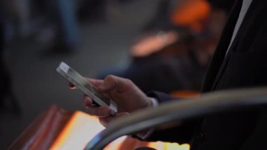 Freelancer mesajlara cevap verir ya da iş e-postalarını akıllı telefondan yazarak metroya biner. Az ışık. İşler tıkırında. İş konsepti. Kapatın. Prores 422