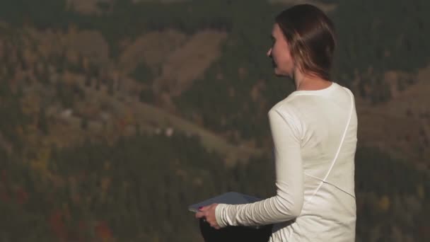 Frilansare ung kvinna med laptop fastställande hennes hår sitter på toppen av ett berg i Karpaterna. Frilansare arbetar på distans med hjälp av ny teknik. Karpaternas berg. Prores 422 — Stockvideo