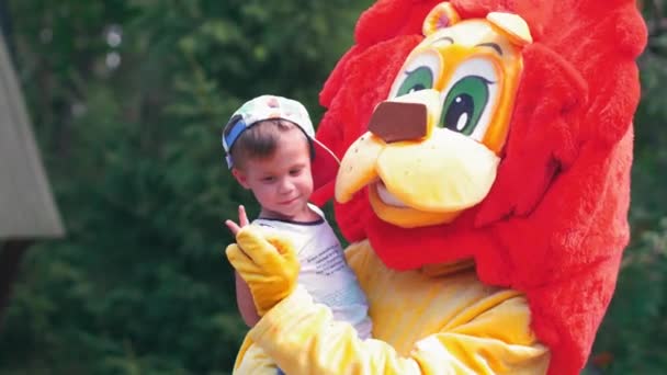 Ein kleiner Junge in den Armen eines Animators in einem guten Löwenkostüm. Eltern mit Kindern verbringen Zeit im Stadtzoo. Juli 2017, Kiew Ukraine. Prores 422 — Stockvideo