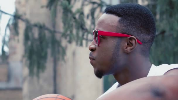 Νεαρός Αφροαμερικάνος φοιτητής που παίζει μπάλα έξω με την συμμαθήτριά του και μιλάει για κάτι. Φοιτητές φίλοι περνούν χρόνο στο πανεπιστήμιο. Κλείσε. Γραμμένο υλικό. Πρότυπα 422 — Αρχείο Βίντεο
