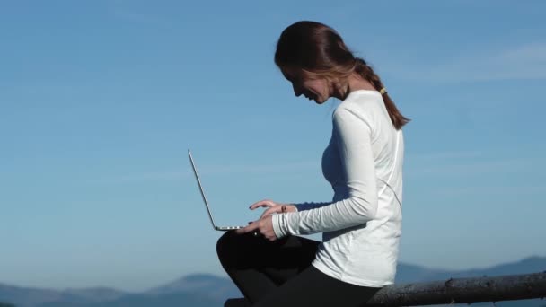 Szabadúszó lány dolgozik laptop ül egy hegy tetején, csodálatos kilátás nyílik a Kárpátok. Szabadúszó a munka távolról használja az új technológiák. A Kárpátok hegyei. Gyümölcsfélék — Stock videók