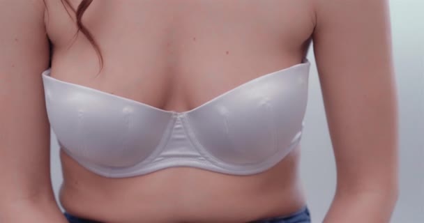 Concepto de cáncer de mama. Foto de cuerpo de un pecho de mujer bonita en sujetador de encaje blanco. El concepto de implantes mamarios de silicona. Cirugía plástica. Mujer pechos tratamiento médico. Prores 422 — Vídeo de stock