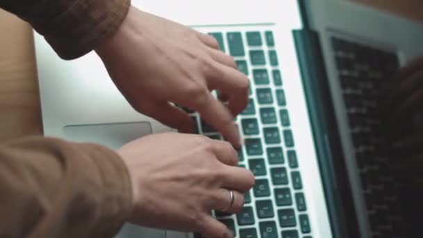 Vista de ángulo superior.Manos de mujer escribiendo en el teclado del ordenador portátil sentado en el alféizar de la ventana. Mujer con chaqueta marrón usando computadora. Concepto de negocio. Prores 422 — Vídeos de Stock