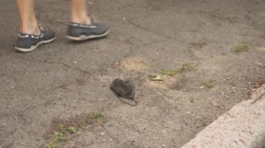 İnsanlar yolda yatan siyah maskeye basıyor. Karantina yaşam tarzı. Nefes koruması..