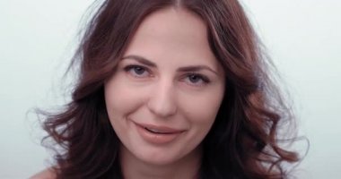 Kadın kameraya bakıp sitem ediyor ve gülüyor. Alay ediyor. Kibirli görünüyor.