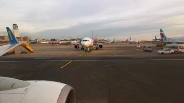 Uçak Avusturya 'daki Viyana Havaalanı' nda pist boyunca ilerliyor. Kalkışa hazırlanıyorum. Uçak penceresinden bak. Arka planda havaalanında çalışıyorum. 26 Aralık 2019. Viyana, Avusturya