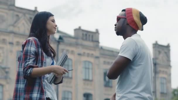 Chica caucásica comunicarse con chico afroamericano. Estudiantes concepto de amistad. .. Imágenes de alta calidad 4k — Vídeos de Stock