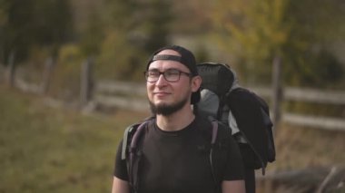 Sırt çantasında yürüyen bir adam dağlara bakmak için gözlerini kapatmak için elini kaldırır. Seyahat yaşam tarzı seyahat konsept macera açık hava yaz tatilleri vahşi doğa Karpatya Dağları. Prores 422