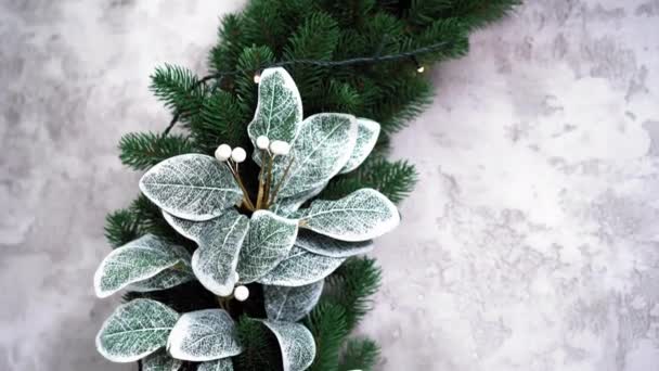 Dekoracyjny listowie w drugi na iglasty gałąź. Dekoracyjny świąteczny wieniec ozdobiony sztucznymi srebrnymi kwiatami. Wysokiej jakości materiał 4k — Wideo stockowe
