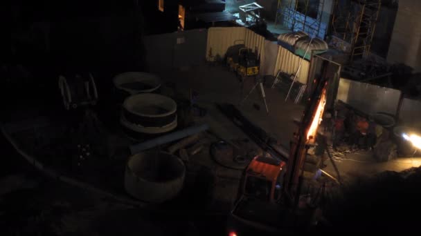 Grävmaskinen gör en U-sväng. Natt på en byggarbetsplats. Arbetarna står upp. Hög kvalitet 4k video. 26 juni 2020 Kiev, Ukraina — Stockvideo